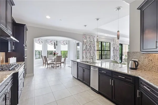 a large kitchen with granite countertop a large counter top space appliances and cabinets