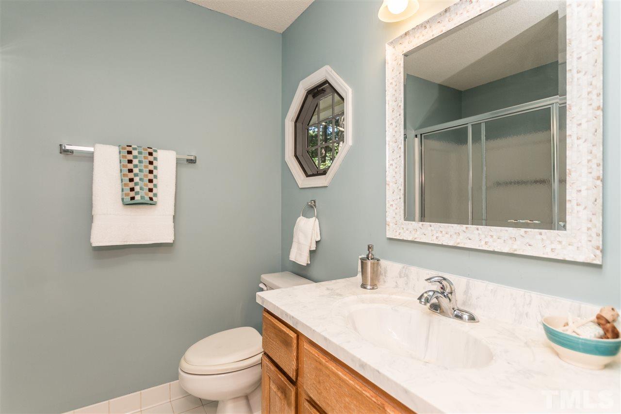 5606 Red Coach Road Durham, NC 27712 - Photo 17 of 25 a bathroom with a toilet a sink and a mirror