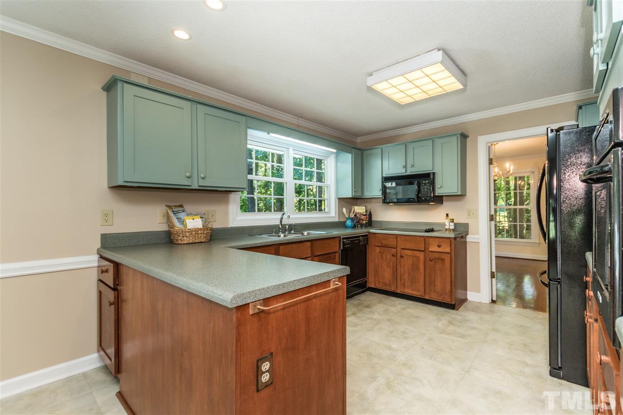 5606 Red Coach Road Durham, NC 27712 - Photo 9 of 25 a kitchen with stainless steel appliances granite countertop a sink stove refrigerator and a window