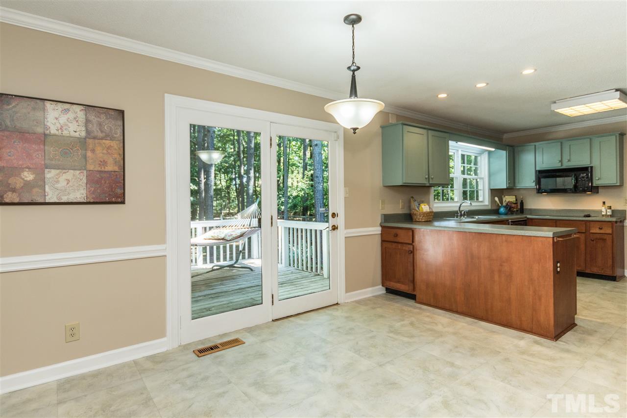 5606 Red Coach Road Durham, NC 27712 - Photo 10 of 25 a kitchen with stainless steel appliances granite countertop a stove a sink and a refrigerator with wooden floor