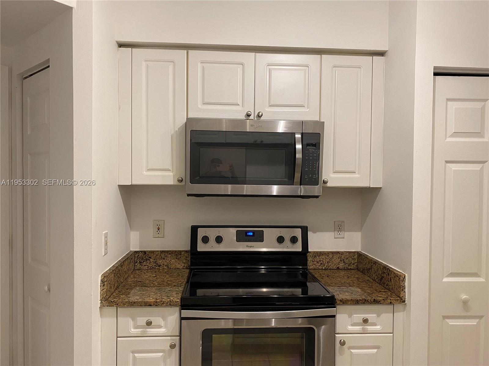 17150 North Bay Road, Unit 2119 Sunny Isles Beach, FL 33160 - Photo 4 of 41 a kitchen with stainless steel appliances granite countertop white cabinets and a stove a oven with white countertops