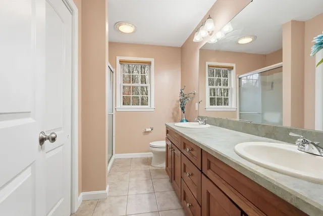 a bathroom with a granite countertop sink a mirror a vanity and a shower