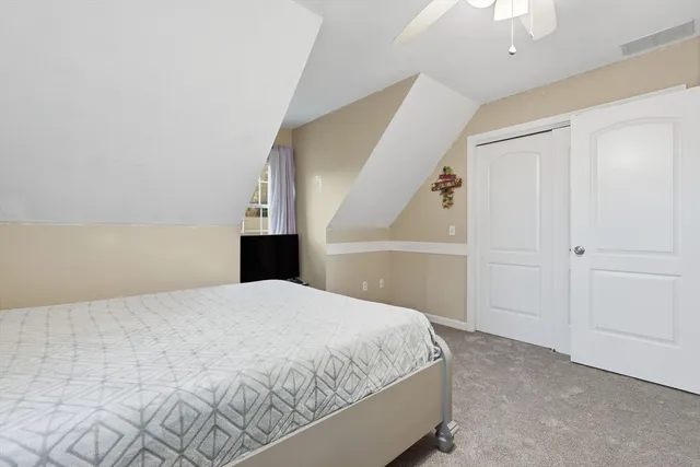 a bedroom with a bed and a painting on the wall