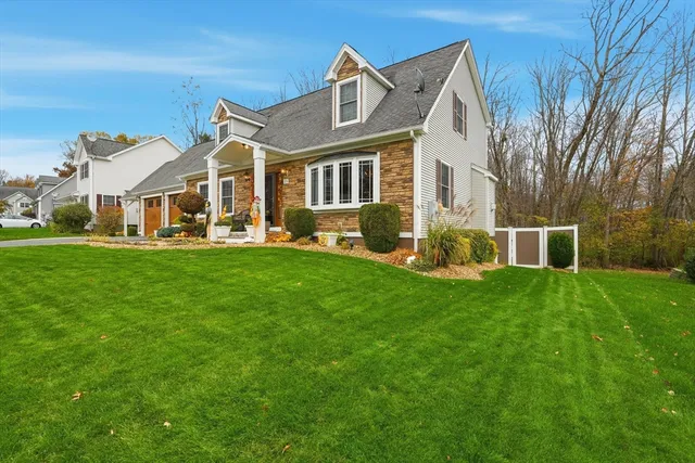 a front view of a house with a garden and trees
