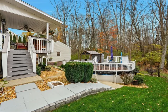 a view of a house with large trees and a yard