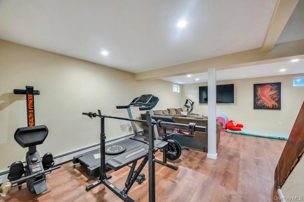 39 Bevin Road Northport, NY 11768 - Photo 35 of 44 Basement Exercise area featuring light wood-type flooring, baseboard heating, beam ceiling, and recessed lighting