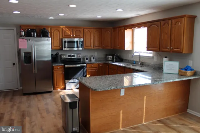 a kitchen with stainless steel appliances granite countertop a sink refrigerator and microwave