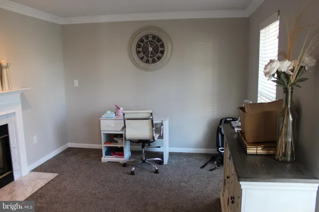 a view of a workspace with furniture and a window