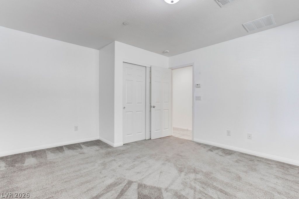 4650 Ranch House Road, Unit 47 North Las Vegas, NV 89031 - Photo 35 of 43 A well-lit bedroom features plush gray carpeting and crisp white walls.