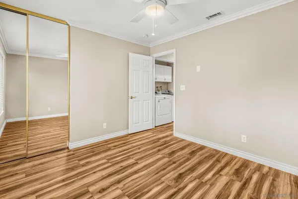 a view of an empty room with wooden floor