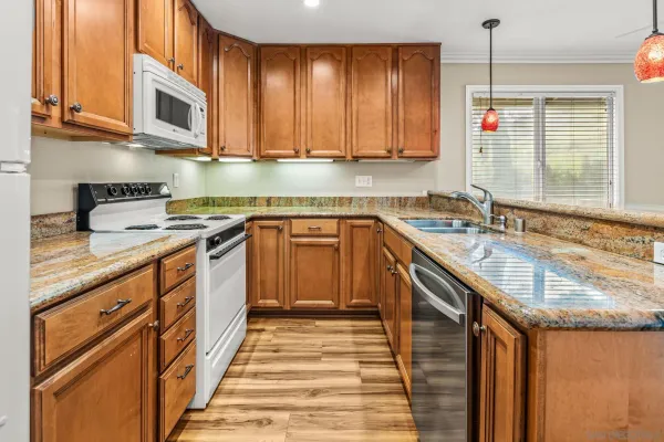 a kitchen with stainless steel appliances granite countertop a sink a stove and a microwave