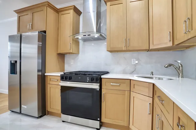 a kitchen with stainless steel appliances granite countertop a stove a refrigerator and a sink