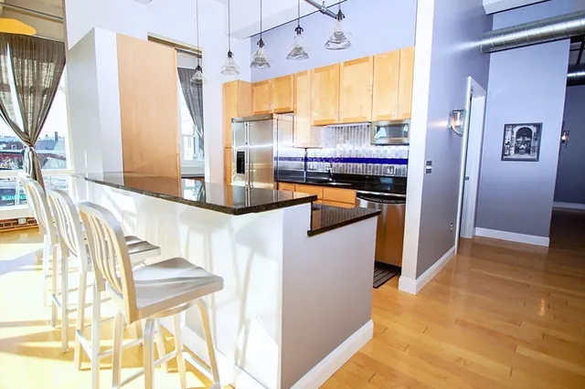 a kitchen with stainless steel appliances granite countertop a refrigerator and a stove