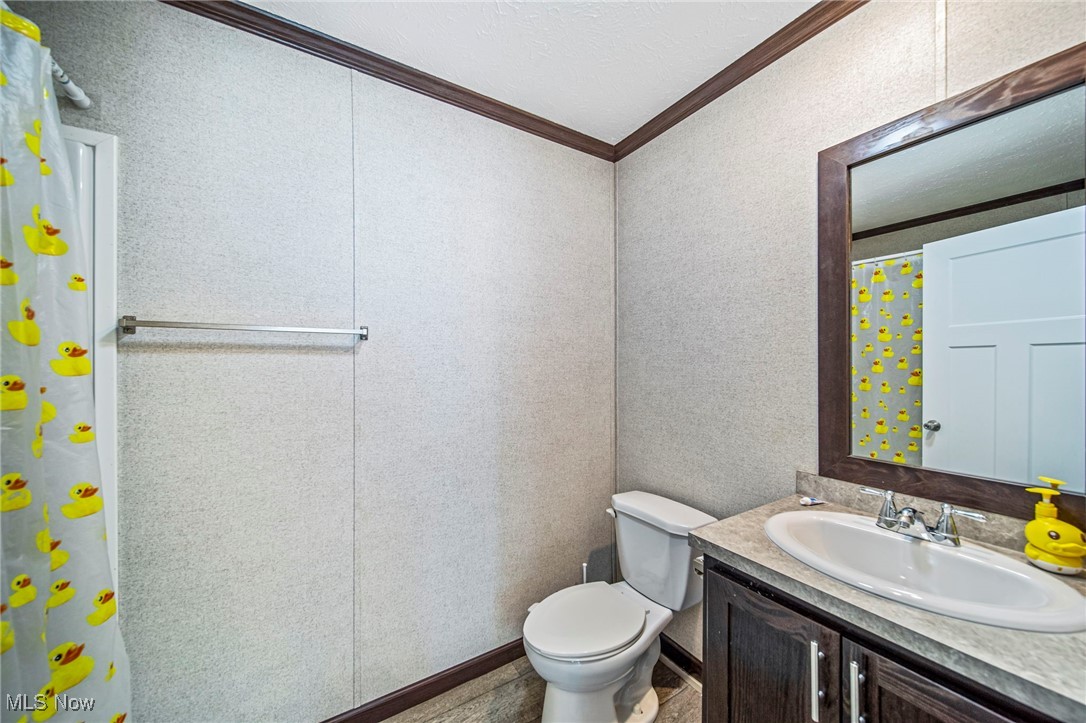 202 West Main Road, Unit LOT 13 Conneaut, OH 44030 - Photo 18 of 23 Full bathroom with crown molding, vanity, water heater, and a textured ceiling