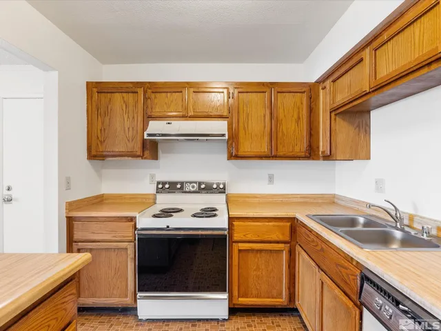 a kitchen with a sink stove top oven and cabinets