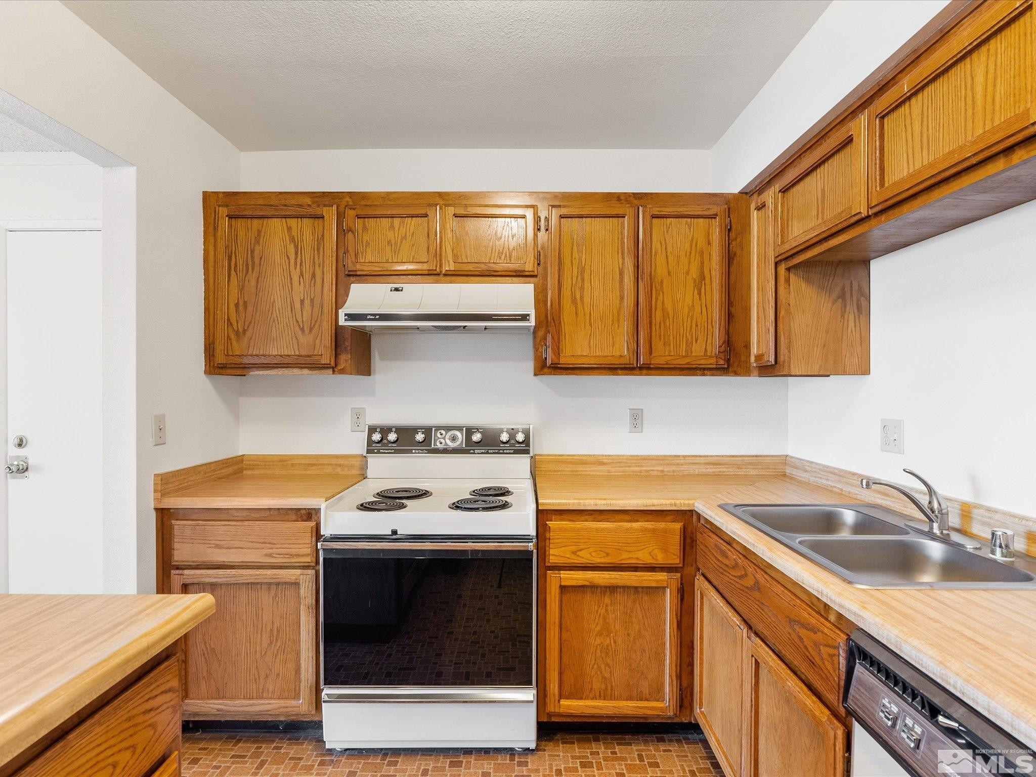 1465 East Peckham Lane, Unit 55 Reno, NV 89502 - Photo 11 of 22 a kitchen with a sink stove top oven and cabinets