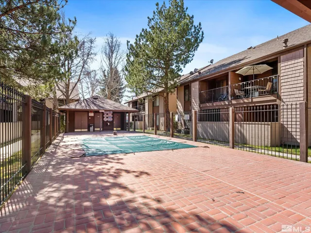 a front view of a house with a yard and large trees