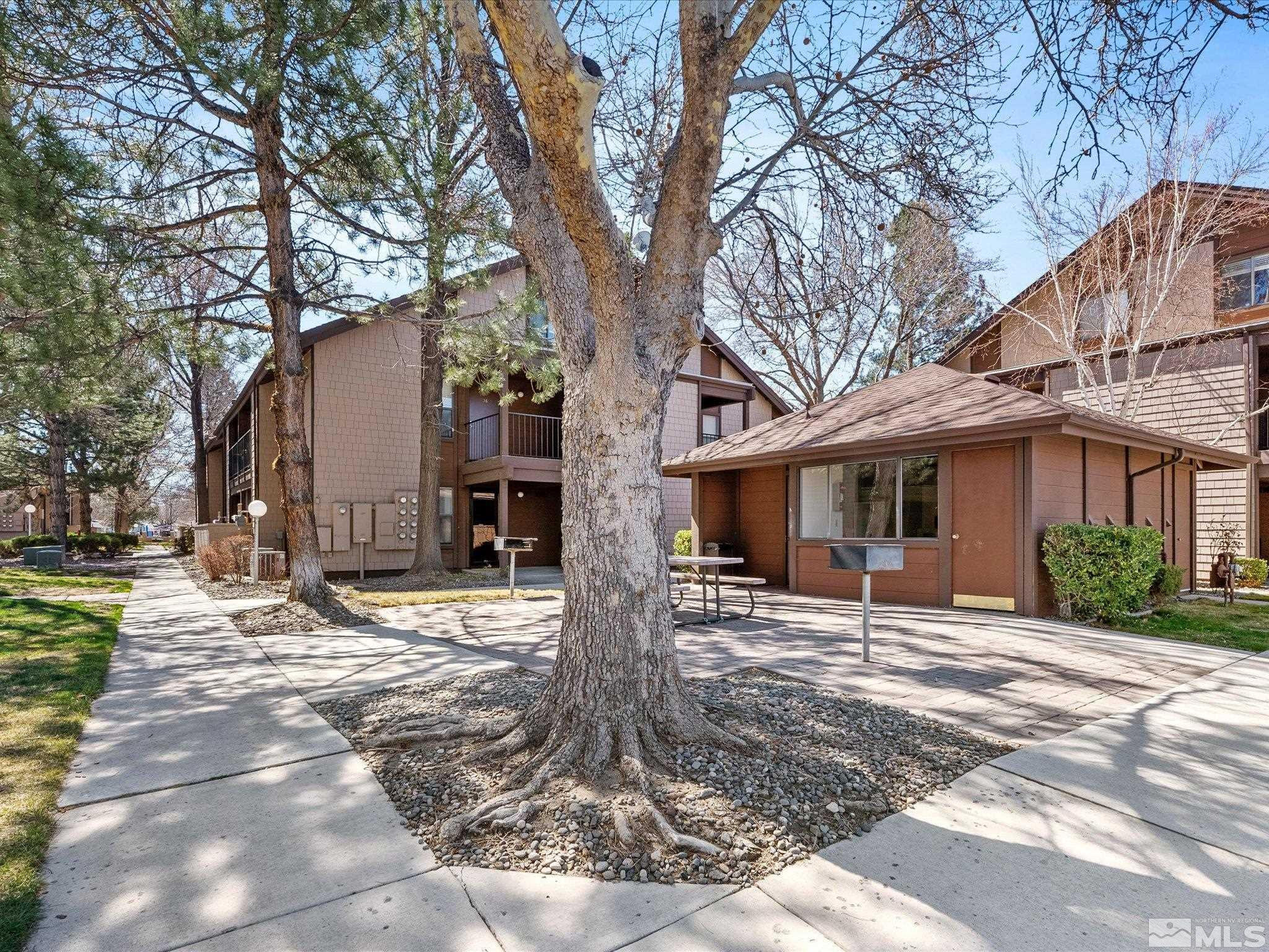 1465 East Peckham Lane, Unit 55 Reno, NV 89502 - Photo 22 of 22 a front view of a house with a yard and large trees