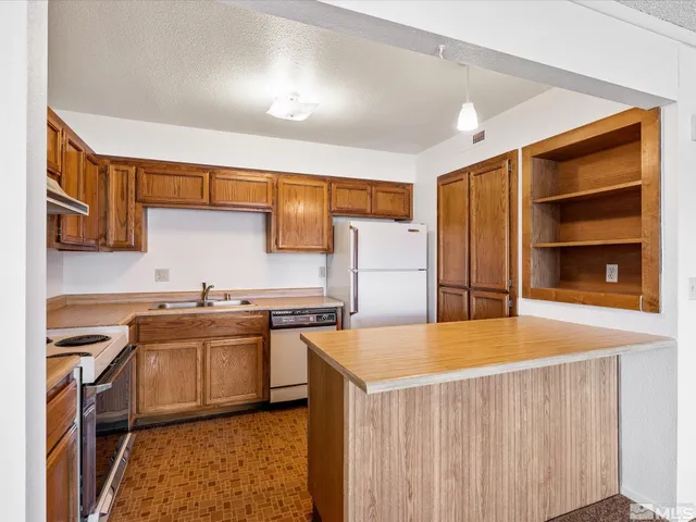 a kitchen with stainless steel appliances a stove a sink and a refrigerator
