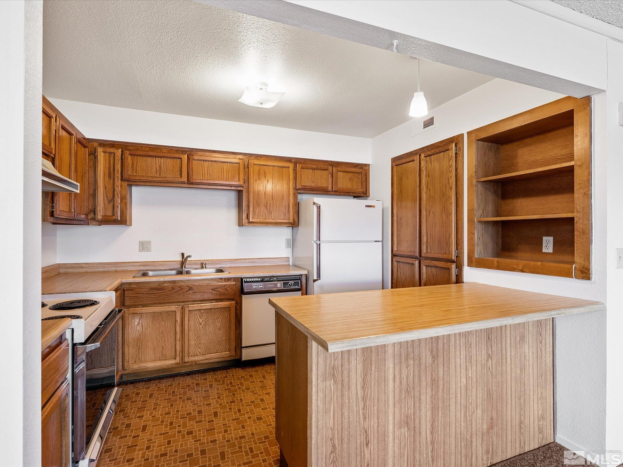 1465 East Peckham Lane, Unit 55 Reno, NV 89502 - Photo 9 of 22 a kitchen with stainless steel appliances a stove a sink and a refrigerator