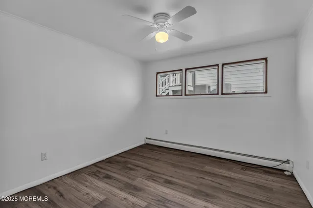 a view of a room with wooden floor and a ceiling fan
