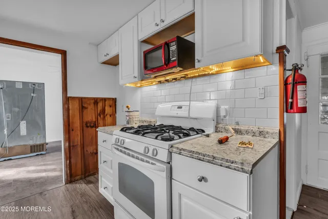 a kitchen with stainless steel appliances granite countertop a stove and a microwave