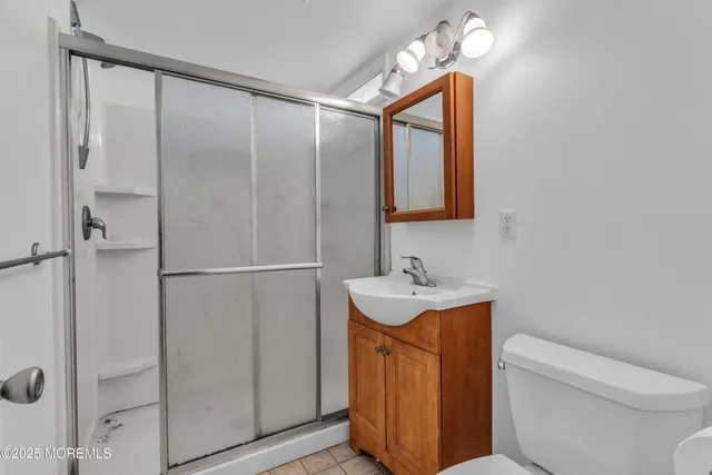 a bathroom with a toilet sink vanity and mirror