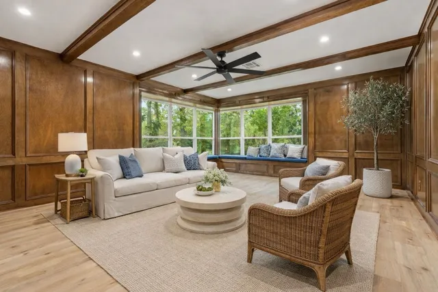 a living room with furniture a large window and a table