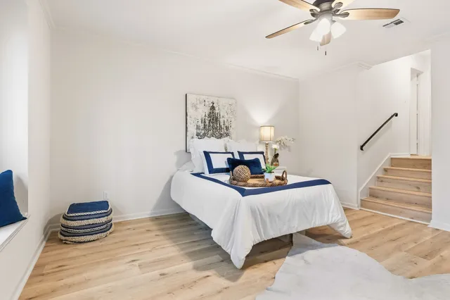 a bedroom with a bed wooden floor and a chandelier