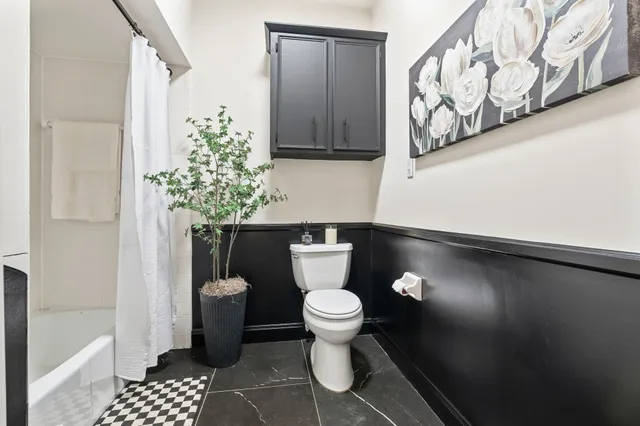 a bathroom with a toilet and a shower curtain