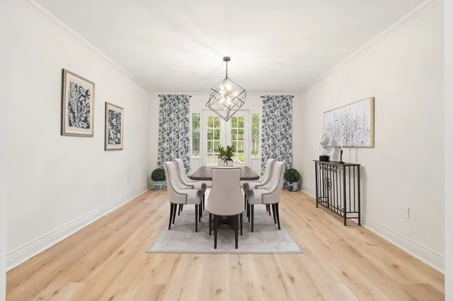 a dining room with furniture a chandelier and wooden floor