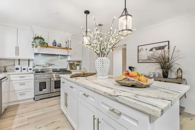 a kitchen with a sink a stove and cabinets
