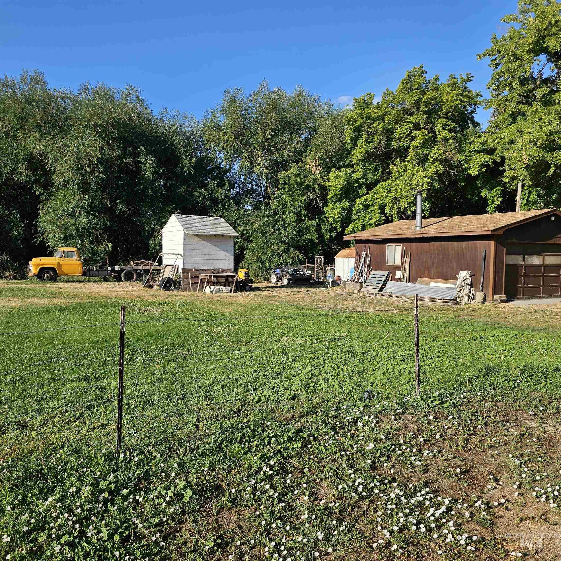 2141 East Syringa Street Eagle, ID 83616 - Photo 7 of 26 View of green lawn with a garage and an outdoor structure