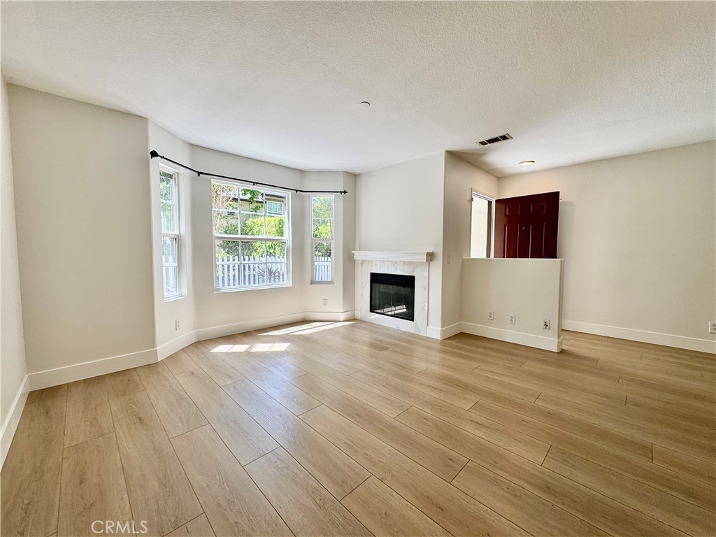 30 Three Vines Court Ladera Ranch, CA 92694 - Photo 7 of 36 an empty room with wooden floor fireplace and windows