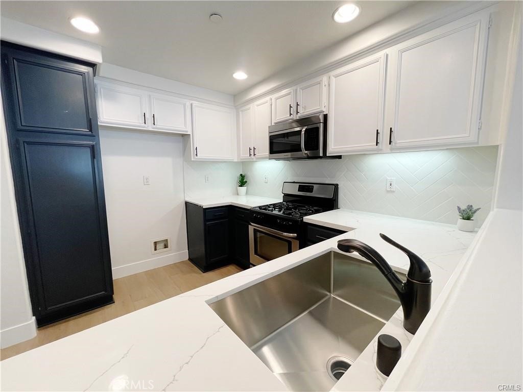 30 Three Vines Court Ladera Ranch, CA 92694 - Photo 9 of 36 a kitchen with stainless steel appliances a refrigerator sink and cabinets