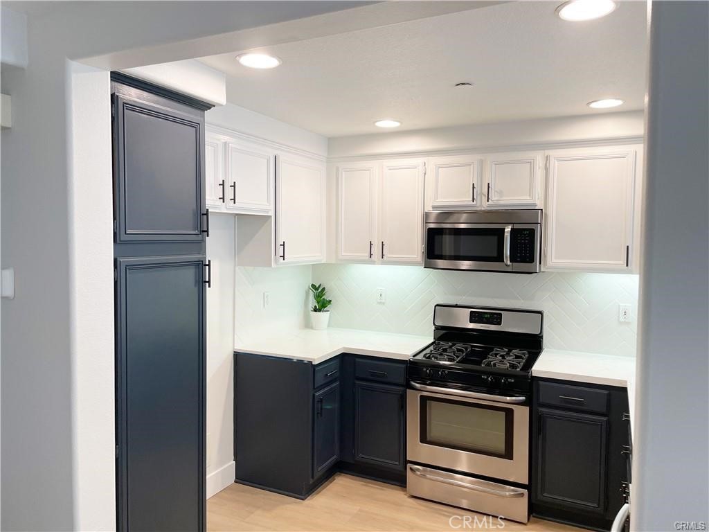 30 Three Vines Court Ladera Ranch, CA 92694 - Photo 10 of 36 a kitchen with stainless steel appliances white cabinets and stove top oven