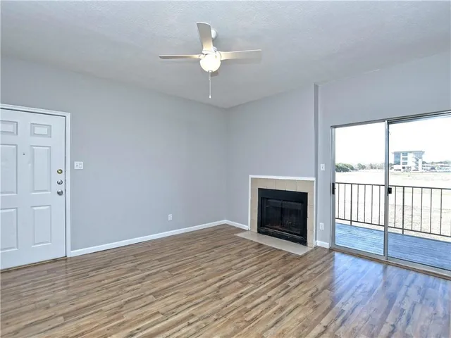 wooden floor fireplace and windows in an empty room