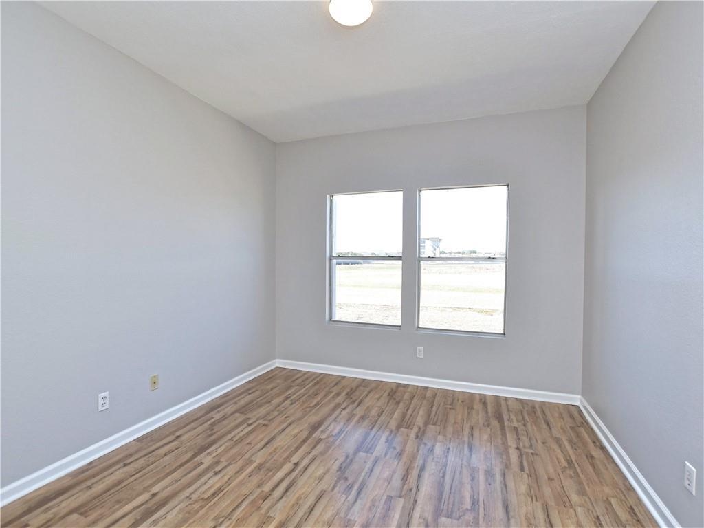 12166 Metric Boulevard, Unit 2015 Austin, TX 78758 - Photo 13 of 18 an empty room with wooden floor and windows