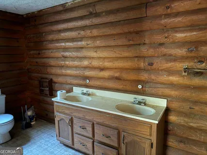 a utility room with stainless steel appliances wooden floor and view of living room