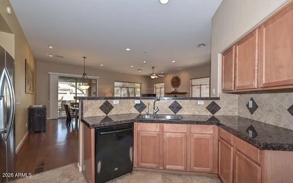 a kitchen with stainless steel appliances granite countertop a refrigerator sink and stove
