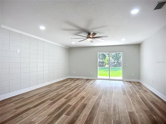 a view of empty room with wooden floor and window