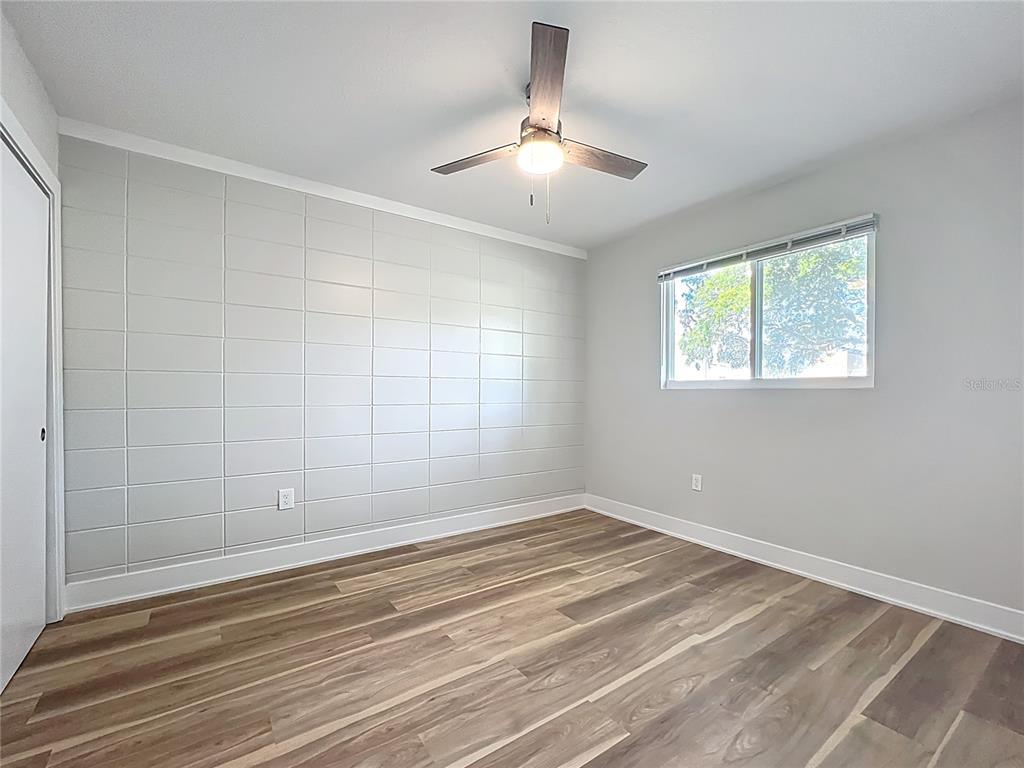 1307 Eagleview Drive Brandon, FL 33510 - Photo 17 of 27 an empty room with chandelier fan and windows