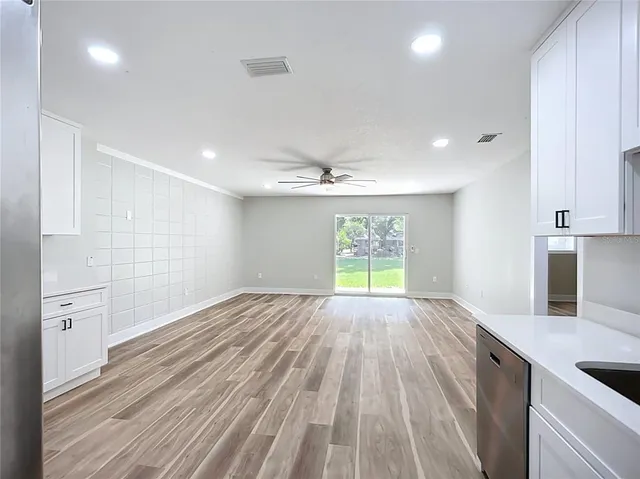 a kitchen with granite countertop cabinets appliances and wooden floor