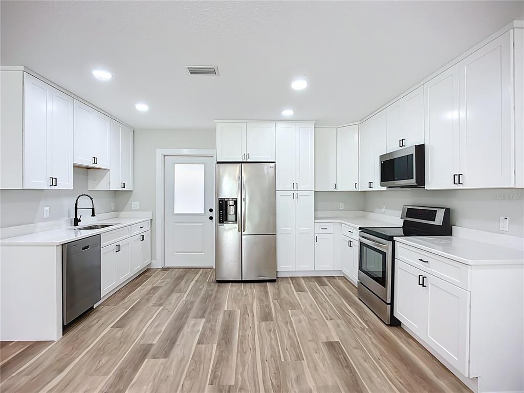 1307 Eagleview Drive Brandon, FL 33510 - Photo 8 of 27 a large kitchen with a lot of white cabinets stainless steel appliances