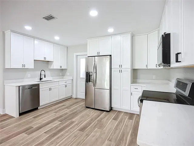 a view of a kitchen with a stove cabinets and wooden floor