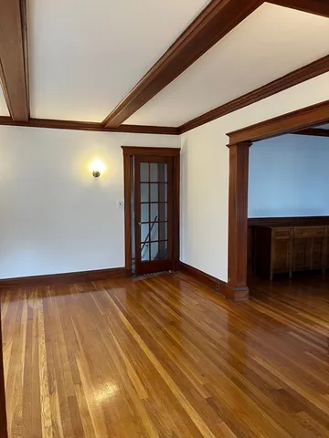 an empty room with wooden floor fireplace and windows