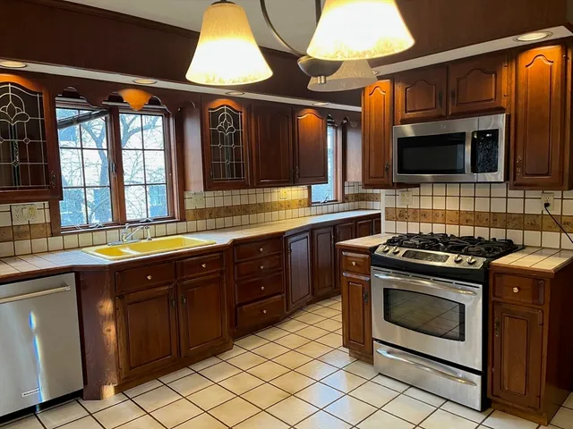 a kitchen with stainless steel appliances granite countertop a stove and a sink
