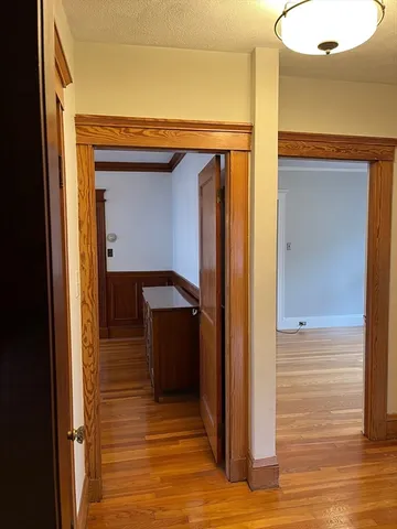 a view of a hallway with wooden floor and entryway