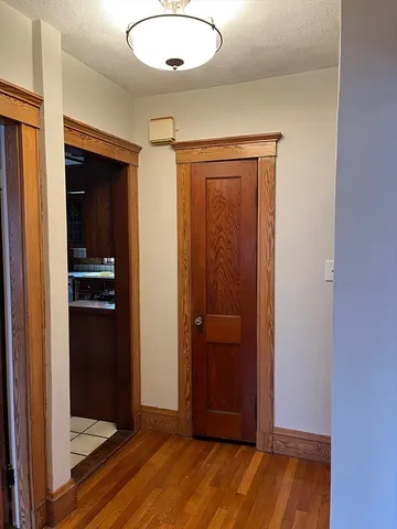 an empty room with wooden floor closet and windows
