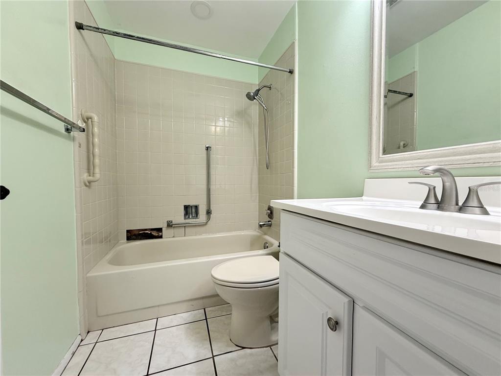 11210 Dollar Lake Drive, Unit 2 Port Richey, FL 34668 - Photo 12 of 15 a bathroom with a sink a toilet a mirror a vanity and shower